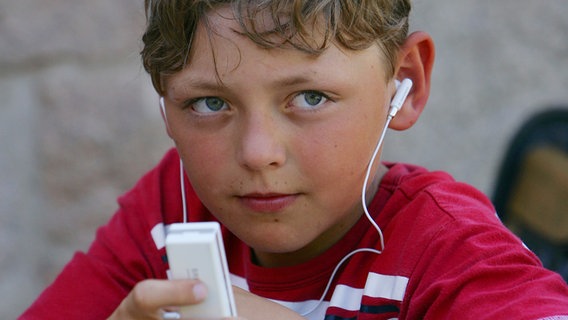 Ein Junge hört Musik mit seinem MP3-Player. © picture-alliance/dpa Foto: Frank May