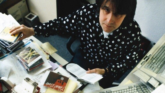 Peter Urban im Jahr 1992 an seinem Schreibtisch auf dem viele CDs liegen. © NDR 