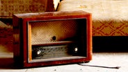Ein altes Radio steht vor einem alten Sofa. © photocase Foto: Allzweck Jack