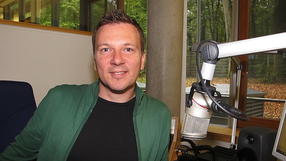 Michael Ahrens sitzt an einem Mikrofon.  Foto: Franz Fanter