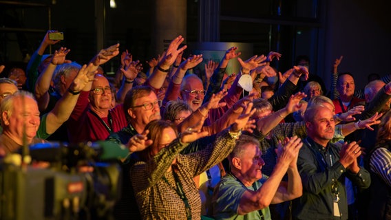 Die Menschen beim Konzert lachen und winken mit ihren Händen © Uwe Pillat 