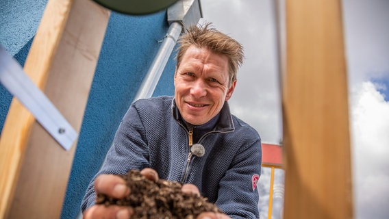 Peter Rasch hält Pflanzenerde in den Händen © NDR 