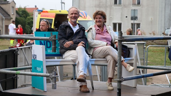 VIP-Gäste sitzen beim NDR Fest in Wolgast auf einer Bank vor der Bühne. VIP-Gäste sitzen beim NDR Fest in Wolgast auf einer Bank vor der Bühne. © NDR Foto: NDR