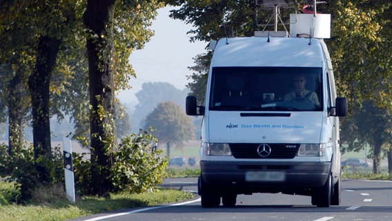 Ein Übertragungswagen des Norddeutschen Rundfunks fährt auf einer baumgesäumten Landstraße. © ndr.de Foto: ndr.de