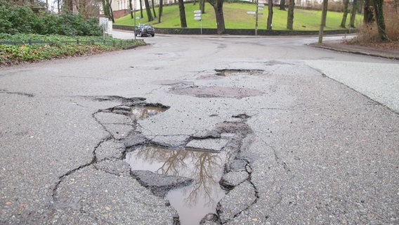 Straßenkreuzung, davor ein Schlagloch  Foto: Henning Strüber