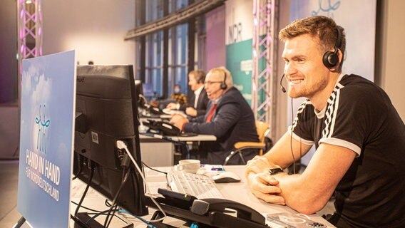 Auch Ruder-Star Hannes Ocik ist extra nach Schwerin gekommen, um am Telefon zu unterstützen. Im Hintergrund: Umweltminister Till Backhaus (SPD) und Schwerins Oberbürgermeister Rico Badenschier (SPD).  Foto: Georg Hundt