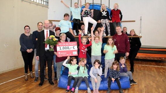 Mitglieder des Sportvereins Strasburg freuen sich über einen Scheck über 1.000 Euro. © NDR Foto: Sven-Peter Martens