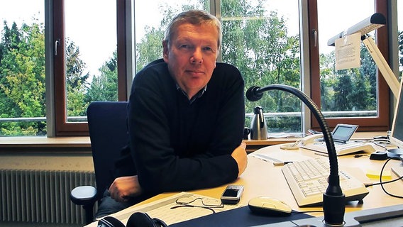 Jörg-Michael Schmidt sitzt an einem Schreibtisch.  Foto: Franz Fanter