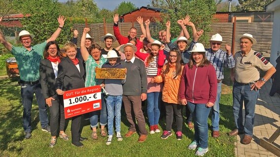 Die Mitglieder des "Junge Imker" des Imkerverein Wittenburg  e.V halten einen Scheck über 1000 € in der Hand und jubeln. © NDR Foto: Andreas Lusky