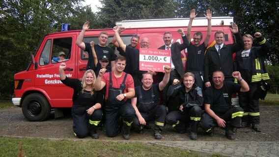 Die Mitglieder der Freiwilligen Feuerwehr Genzkow halten einen Scheck über 1.000 Euro in der Hand. © NDR Foto: Sven Peter Martens