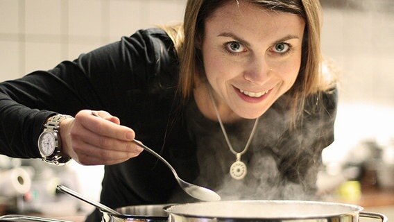 Susanne Grön beugt sich über einen Topf und hält einen Löffel. © NDR Foto: Susanne Grön