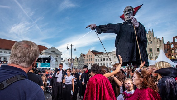 Eine große Vampir-Puppe schwebt über den Menschen. © NDR Foto: Georg Hundt