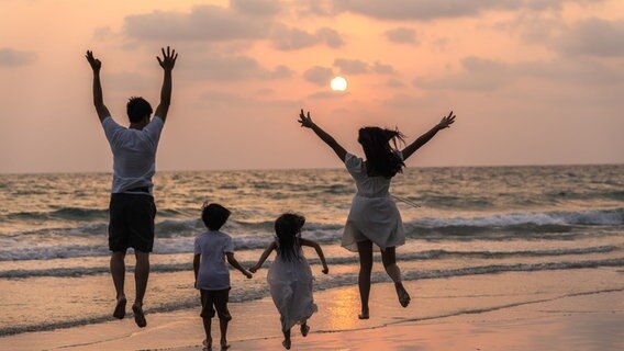 Familie am Strand © Freepik Foto: tirachardz