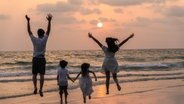 Familie am Strand © Freepik Foto: tirachardz