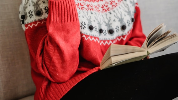 Eine Frau mit Weihnachtspullover liest © pixabay/ Julia Larson 