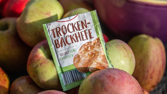 ein Päckchen Trockenbackhefe liegt auf Äpfeln. © NDR Foto: Udo Tanske