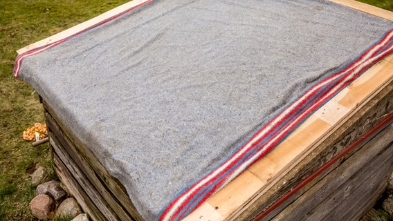 Eine Decke liegt auf dem Deckel eines Hochbeets. © ndr.de Foto: Udo Tanske