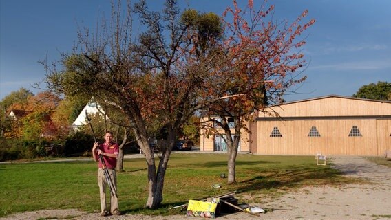 Peter Rasch steht neben einem alten Apfelbaum.  