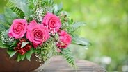 Ein Strauß Rosen in einer Schale auf einem Tisch. © Fotolia.com Foto: bildschoenes