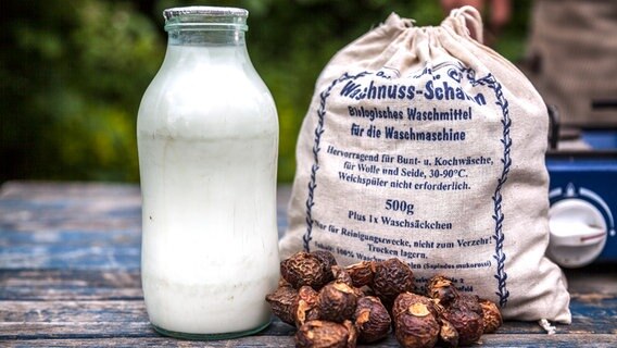 A bottle of milk and soap nuts on a table © NDR Photo: Udo Tanske