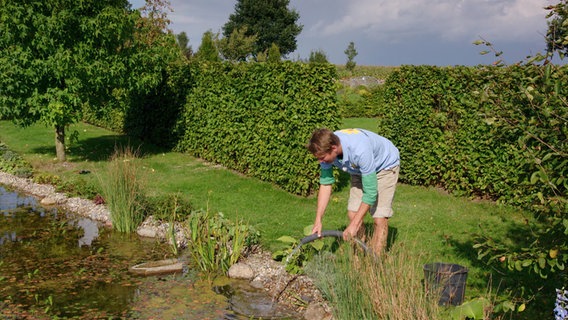 Mit frischem Wasser füllt Peter Rasch den Teich auf. © NDR Foto: Udo Tanske