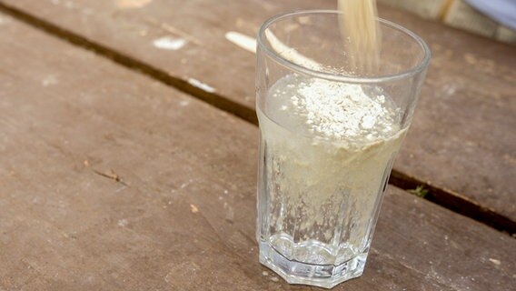 Jemand füllt Nematoden in ein Glas mit Wasser.  Foto: Udo Tanske