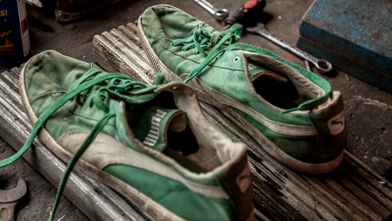 Schuhe mit angenagelten Brettern zum Verdichten von Boden.  Foto: Udo Tanske