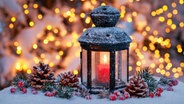 Ein Laterne mit brennender Kerze vor beleuchtetem Hintergrund © xblickwinkel/P.xFrischknechtx 