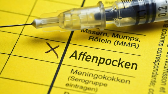 Impfausweis mit dem Schriftzug Affenpocken und eine Impfspritze (Fotomontage). Impfausweis mit dem Schriftzug Affenpocken und eine Impfspritze (Fotomontage). © Imago Foto: Christian Ohde