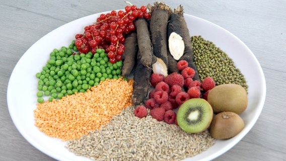 Verschiedene Hülsenfrüchte, Gemüse und Obst auf einem Teller © NDR 