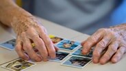 Eine alte Frau spielt Memory.  