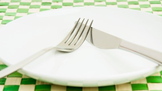 A knife and fork lie on an empty plate.  © image alliance / online agency / Beg 