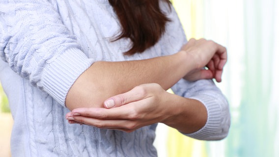 Eine Frau hält ihren schmerzenden Arm. © Fotolia Foto: absolutimages