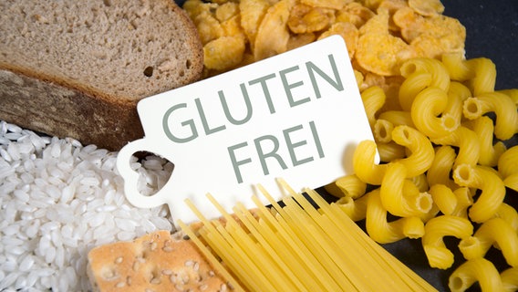 Ein Schild mit der Aufschrift "Gluten Frei" liegt auf verschiedenen Lebensmitteln © fotolia.com Foto: Daniela Stärk