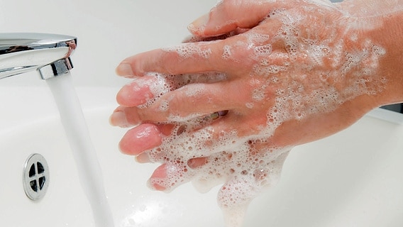 Zwei eingeseifte Hände an einem Waschbecken © imago images / McPhoto 