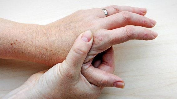 A woman holds her hand © Fotolia.com Photo: Astrid Gast