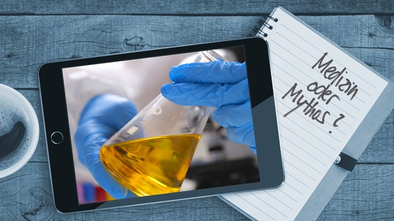 Auf einem Tisch liegt ein Tablet mit einem Bild von einer Urinprobe. Auf einem Notizblock sind die  Worte "Medizin oder Mythos" zu lesen (Montage) © Colourbox Foto: Blackzheep / #257659