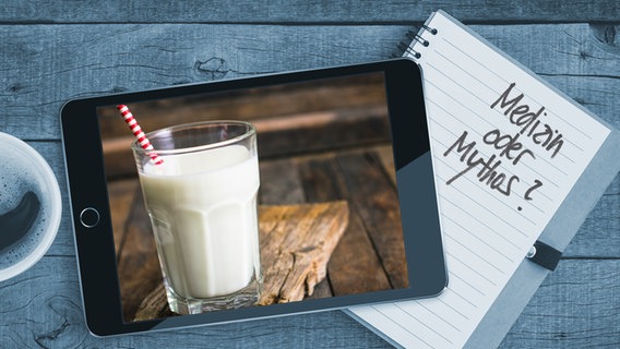 Auf einem Tisch liegt ein Tablet mit einem Bild von einem Glas Milch. Auf einem Notizblock sind die  Worte "Medizin oder Mythos" zu lesen (Montage) © Colourbox/Fotolia Foto: Blackzheep/philipphoto