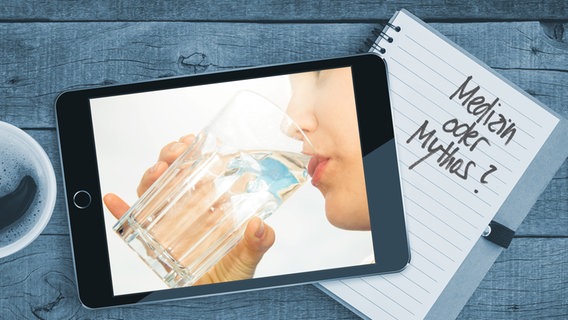 Auf einem Tisch liegt ein Tablet mit einem Bild von Frau, die aus einem Glas Wasser trinkt. Auf einem Notizblock sind die Worte "Medizin oder Mythos" zu lesen (Montage) © Colourbox/Fotoalia Foto: Blackzheep/SandorJackal