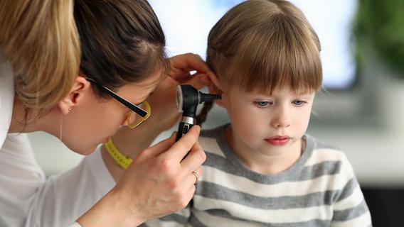 Eine Ohrenärzitin untersucht das Ohr eines kleinen Mädchens. © Colourbox 