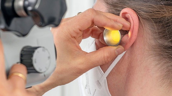 HNO untersucht Gehörgang eines Ohrs mit Hilfe von Trichter und Vergrößerungsgerät © IMAGO / Wolfgang Maria Weber Foto: Wolfgang Maria Weber