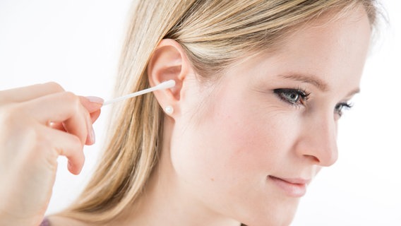 Frau steckt sich Wattestäbchen ins Ohr. © picture alliance / dpa Themendienst | Christin Klose 