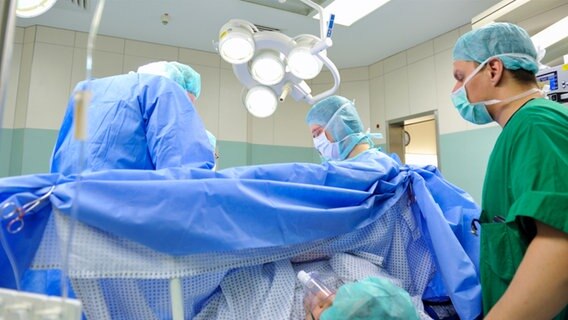 Ärzte bei einer Operation im OP. © fotolia Foto: GordonGrand