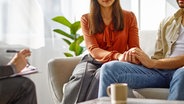 Eine Frau und ein Mann sitzen auf einem Sofa und halten sich an den Händen © colourbox 