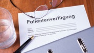 Patientenverfügung, Brille und Stift liegen auf einem Tisch. © Fotolia.com Foto: Jürgen Hüls