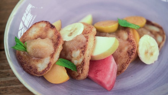Buttermilch-Pfannkuchen mit frischem Obst auf einem Teller angerichtet. © NDR 