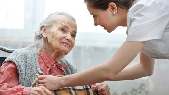 Eine junge Pflegerin kümmert sich um eine alte Frau. © phantermedia Foto: alexraths