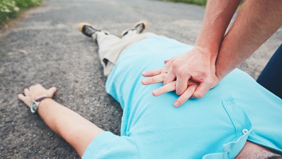Herzdruckmassage an einem auf dem Boden liegenden Mann © colourbox 