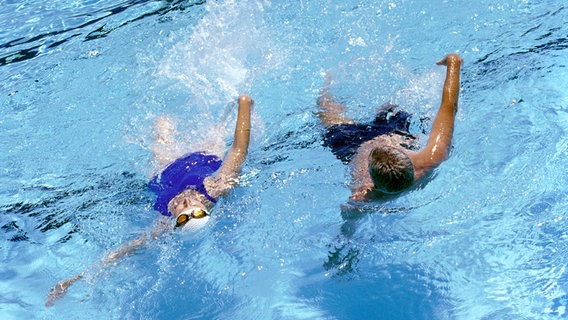 Ein Pärchen schwimmpt in einem Pool. © colourbox Foto: Vincent Hazat