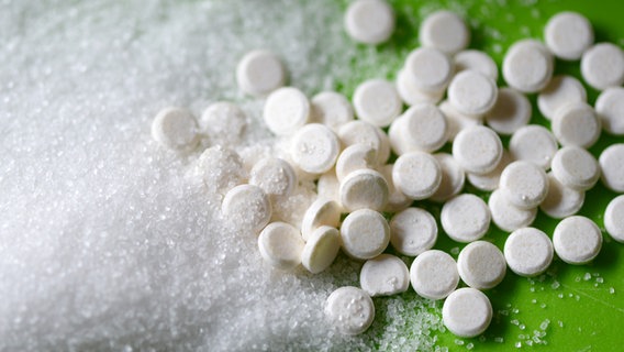 Zucker liegt neben einem anderen Süßungsmittel in Tabletenform. © dpa - Bildfunk Foto: Jens Kalaene